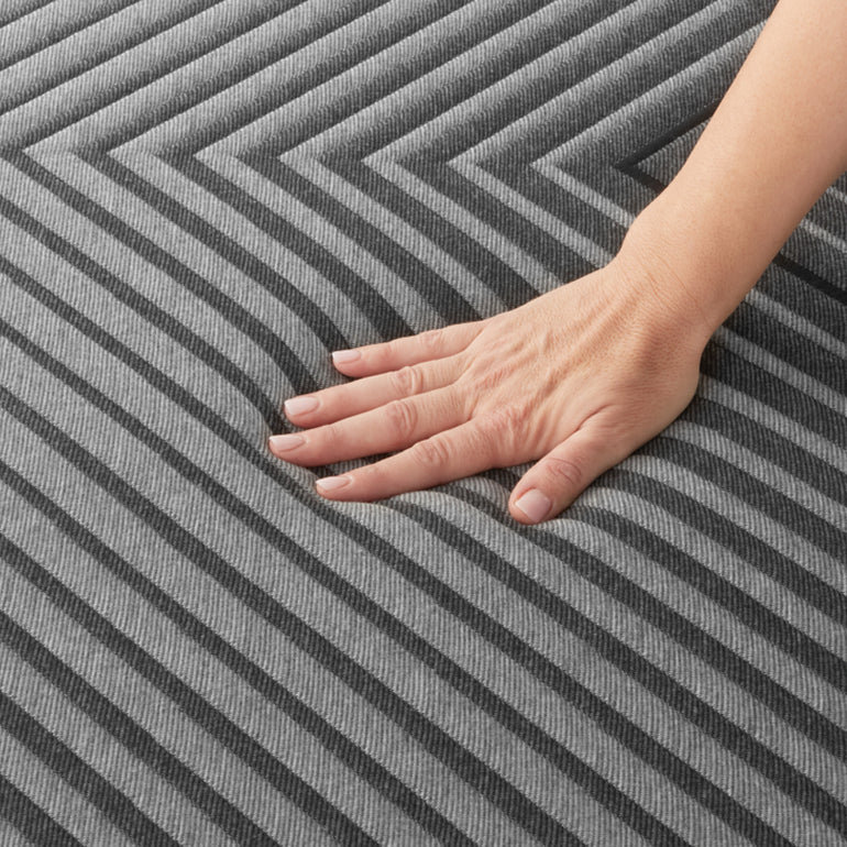 A hand pressing on the fabric of the Beautyrest Black hybrid mattress||series: enhanced lx-class
