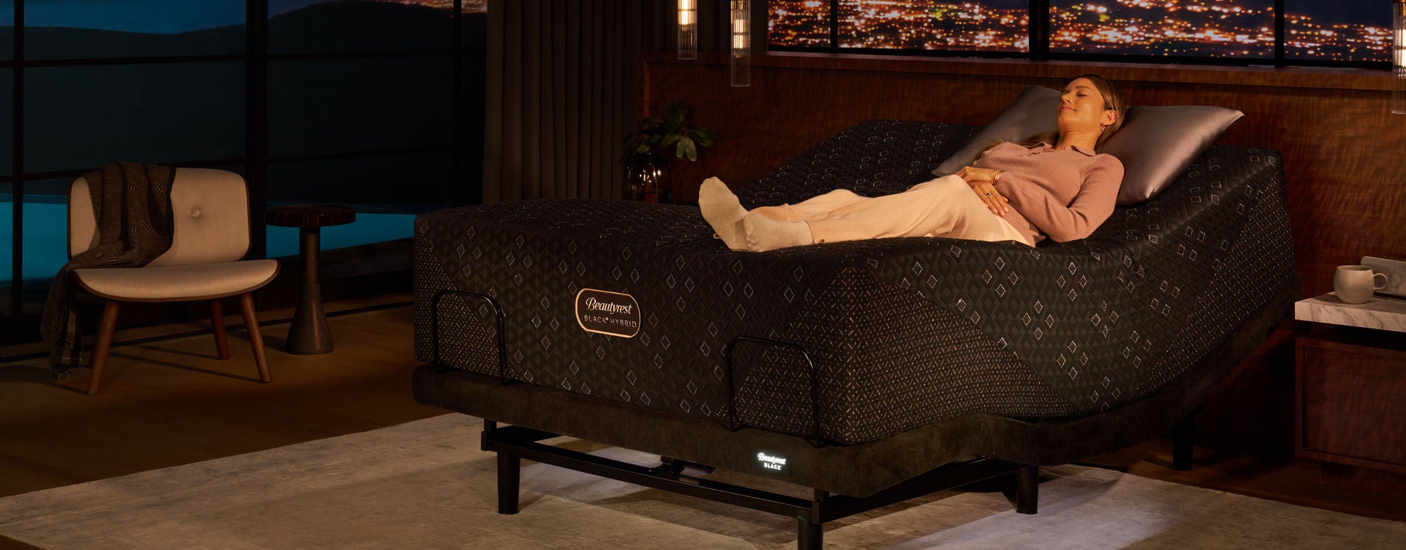 Woman laying on her back on top of a Beautyrest Black Hybrid mattress slightly elevated at the head of the bed on an Beautyrest Black Luxury adjustable base.