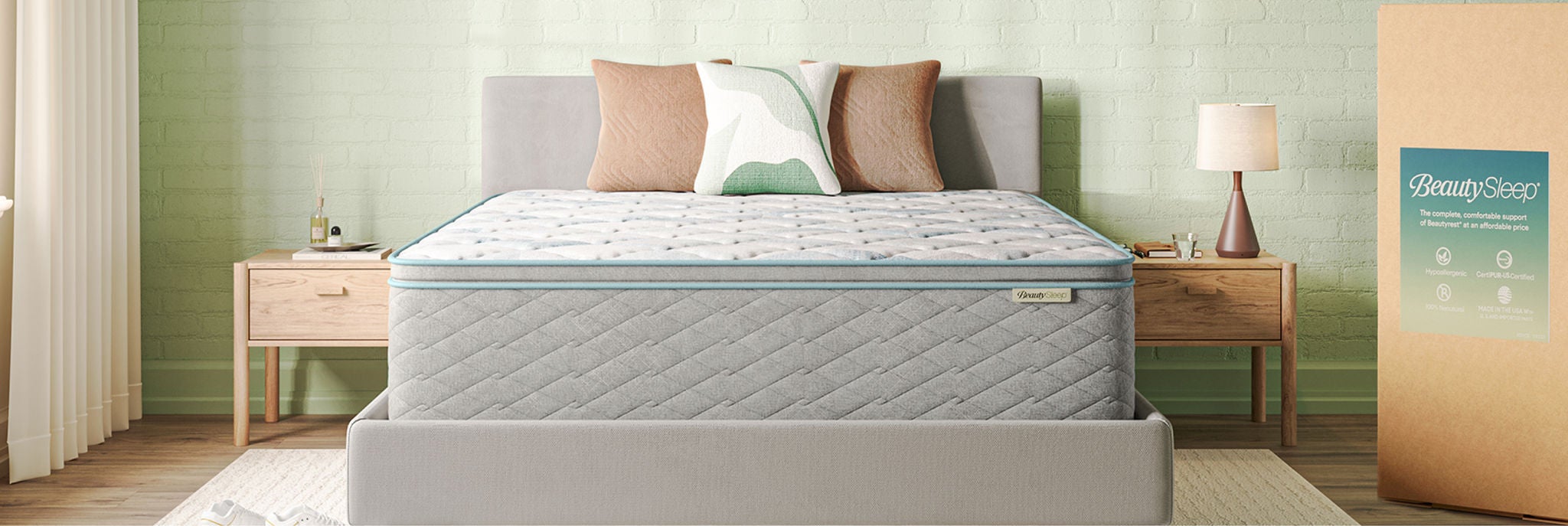 BeautySleep Mattress sitting in a grey bed frame with 3 pillows on top of it.