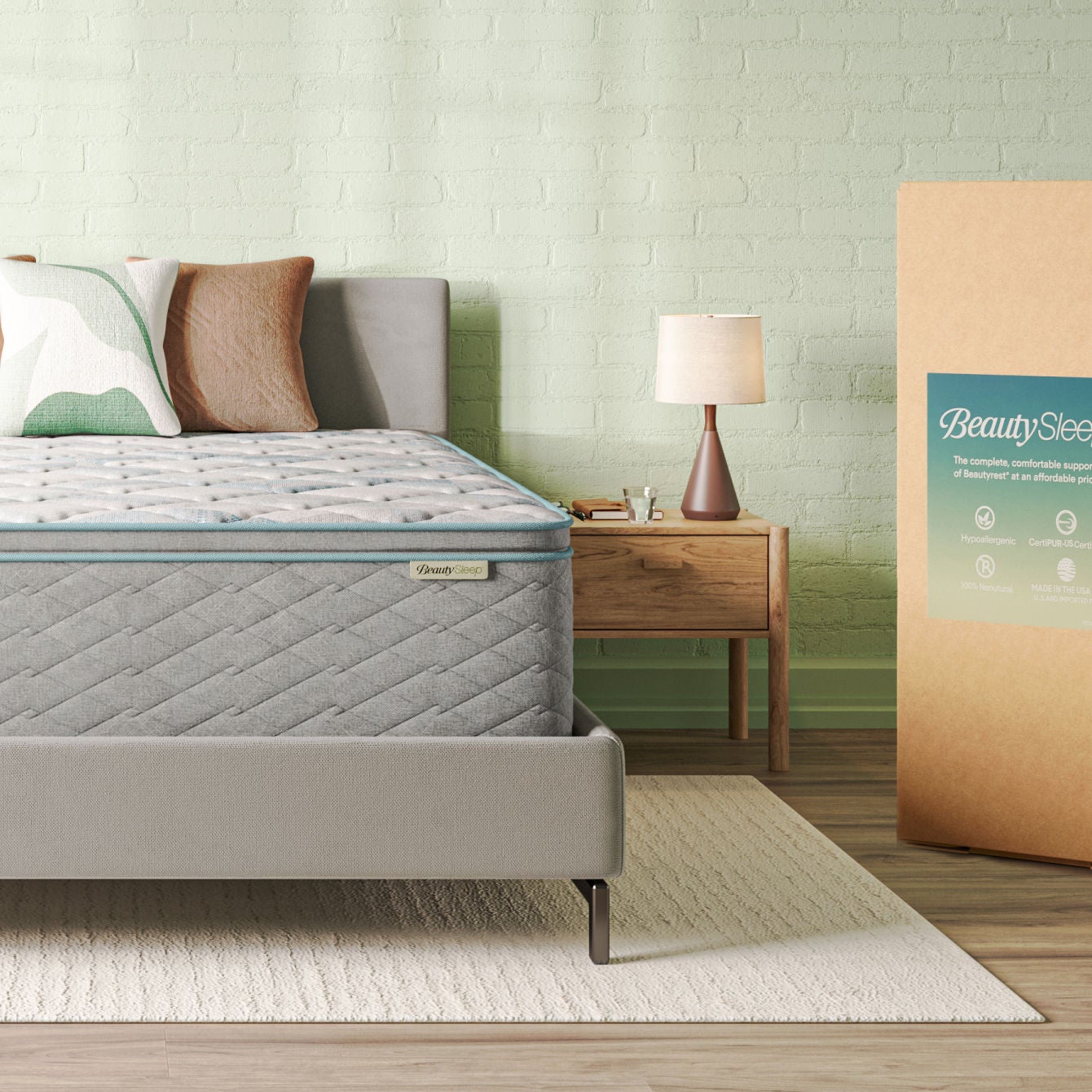 Beautysleep Mattress in a grey bedframe with 2 pillows on top with the mailing packaging on the floor to the right