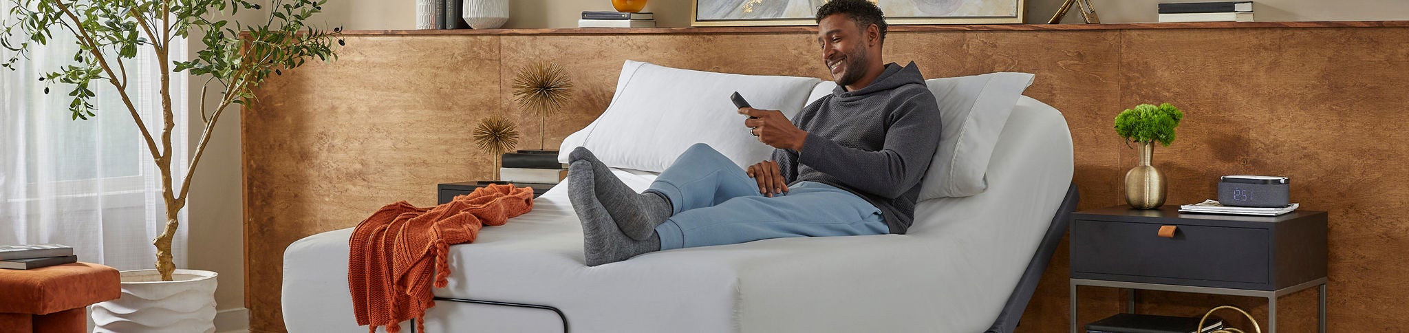 Man relaxing on adjustable bed with remote