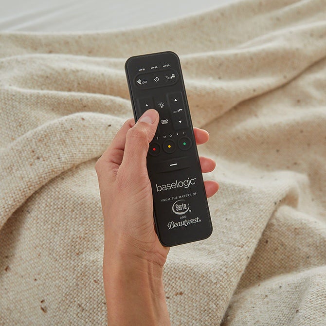 Hand holding remote with visible branding