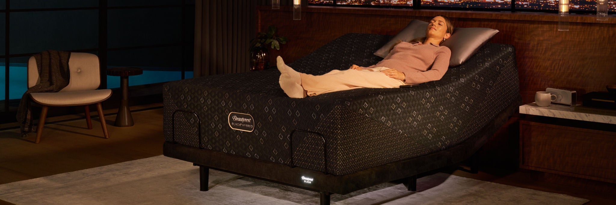 Woman laying on her back on top of a Beautyrest Black mattress in a adjustable base