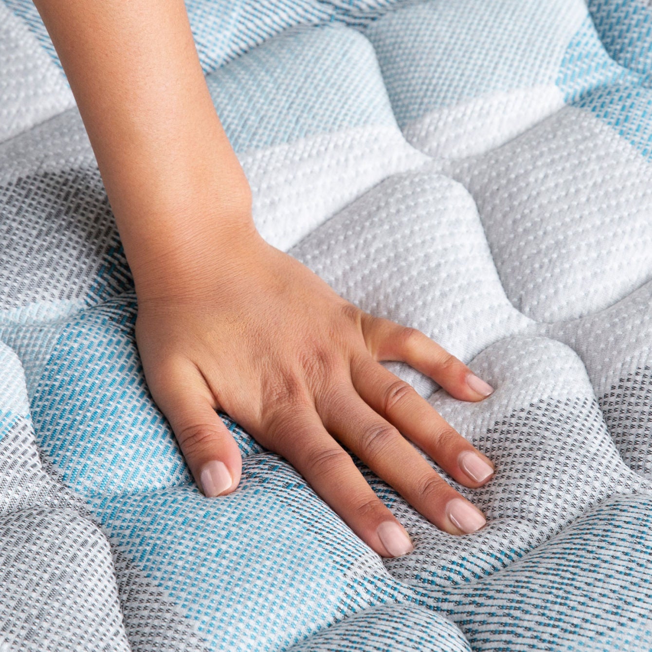 Woman's hand pressing on a Beautyrest mattress