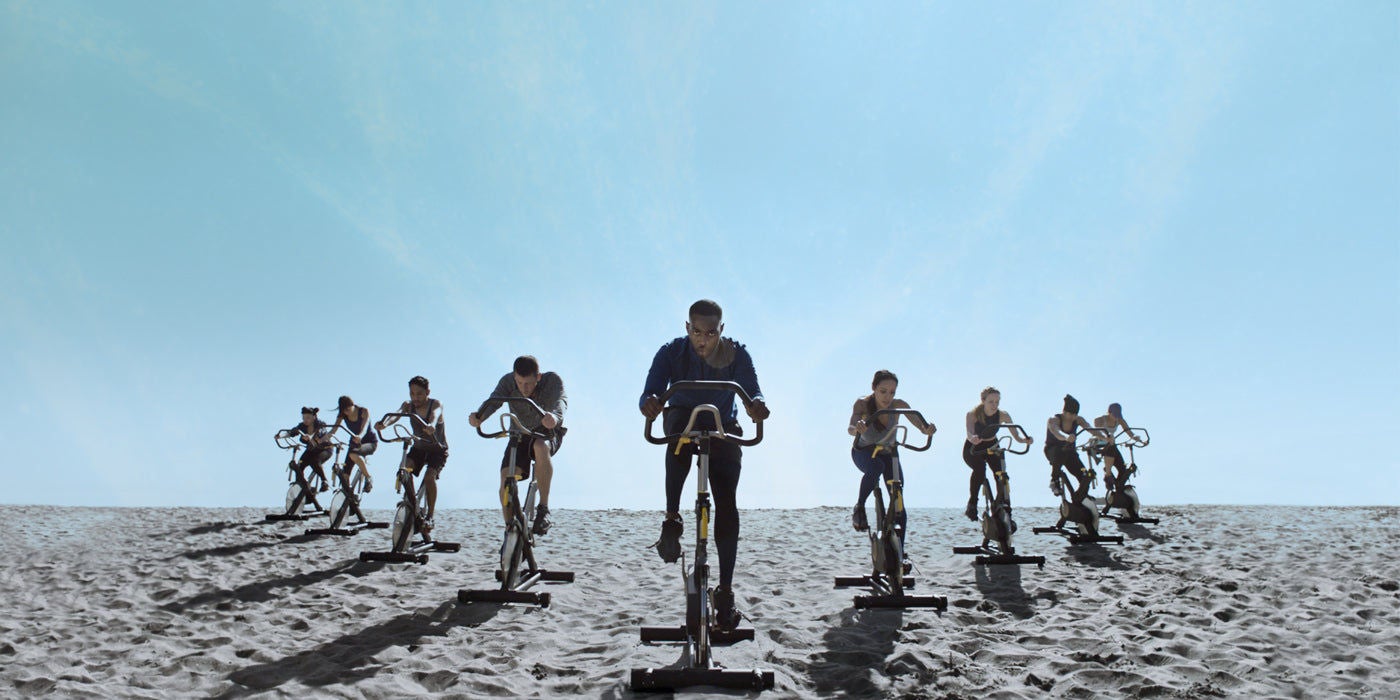 Group cycling workout on sandy beach