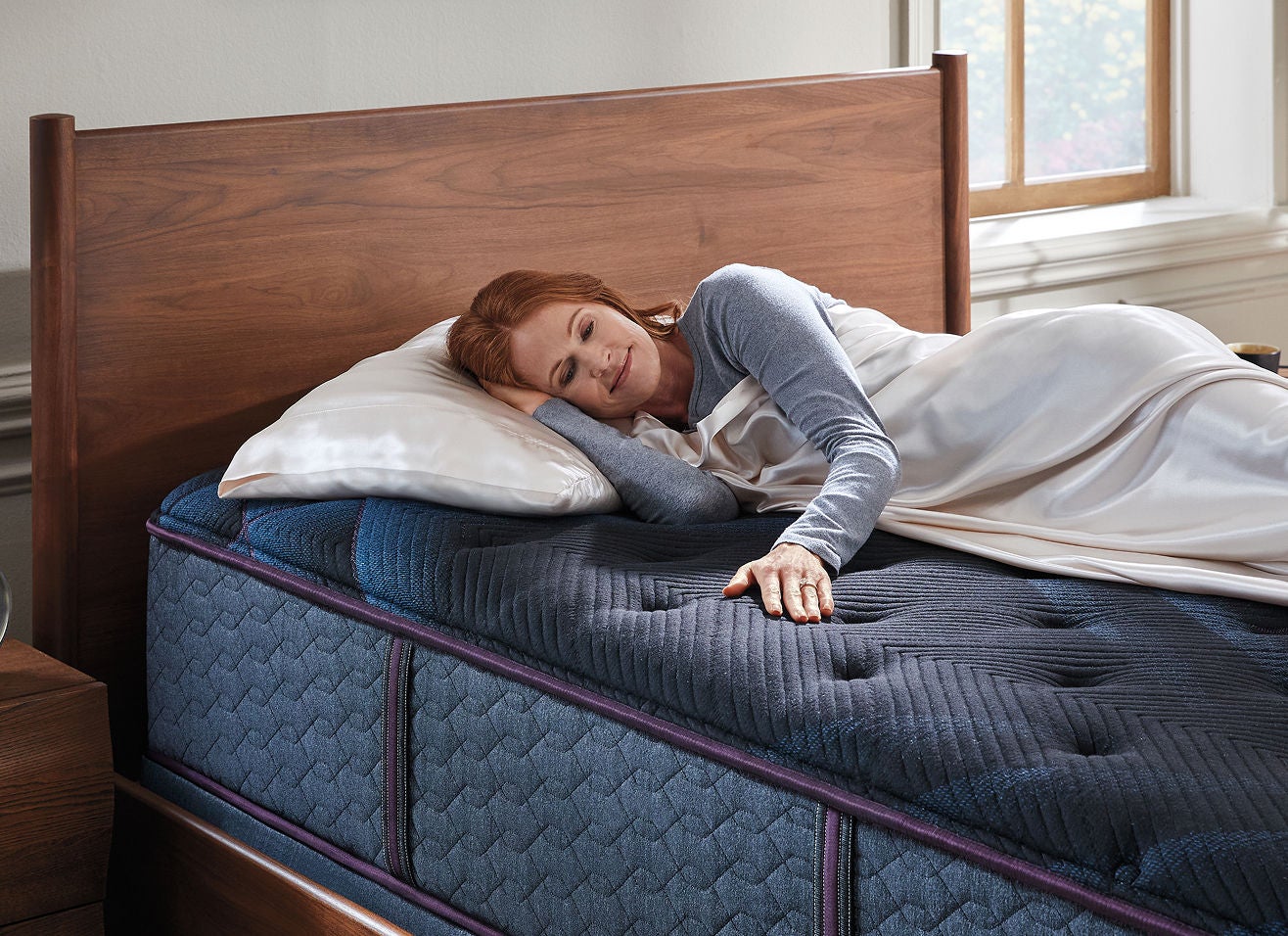 Woman laying on a Beautyrest World Class mattress in a bedroom.