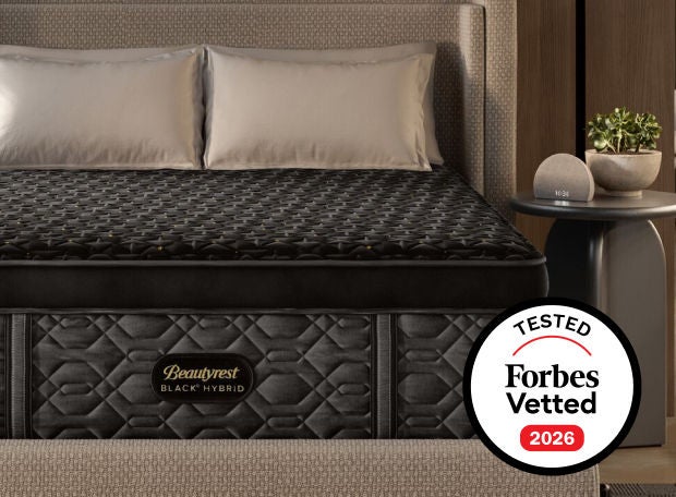 A beautyrest Black hybrid mattress in a bedroom with an award badge from Forbes