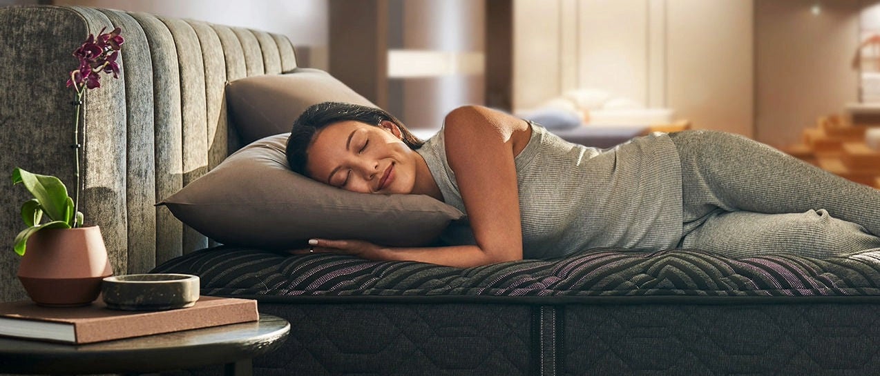 Woman sleeping on modern mattress in cozy room