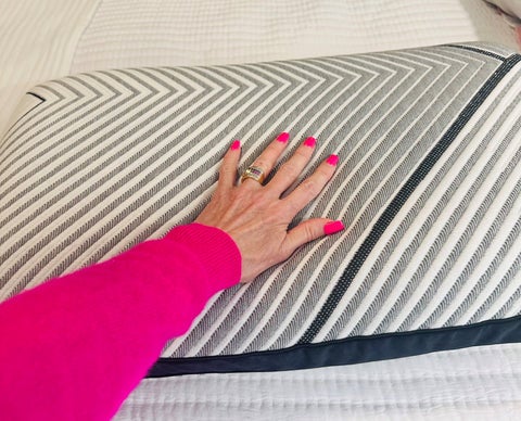 Hand on modern chevron-patterned pillow