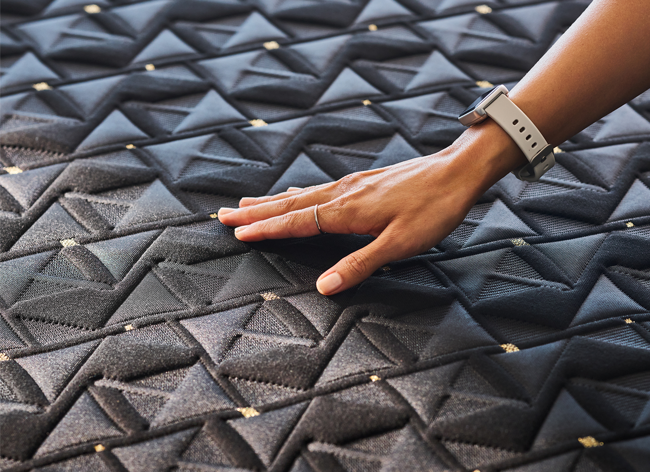 Hand touching textured black fabric surface