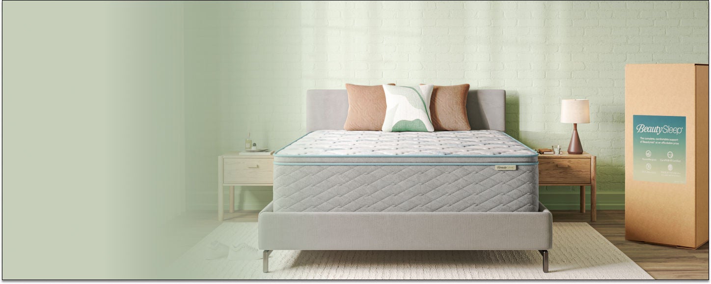 Beautysleep Mattress in a Box in a grey bedframe with 3 pillows on top with the box it was packages in to the right of the bed.