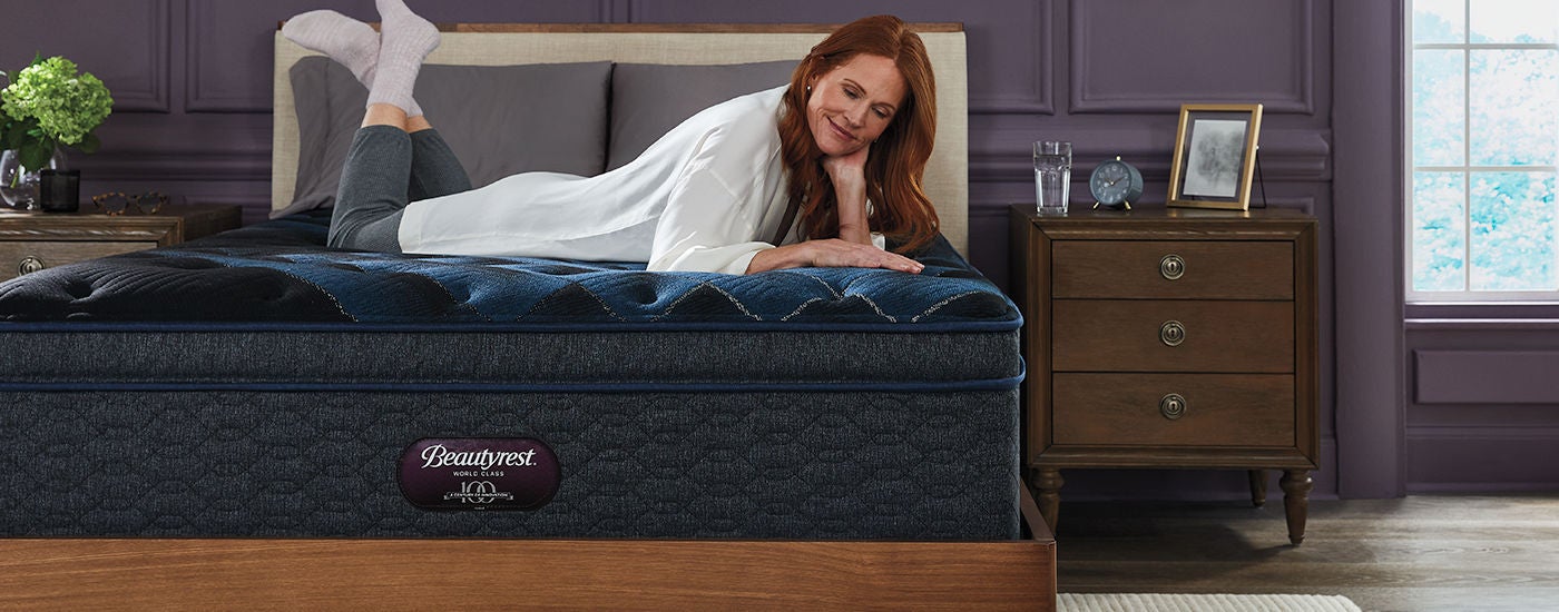 Woman laying on her stomach on top of a Beautyrest World Class mattress.