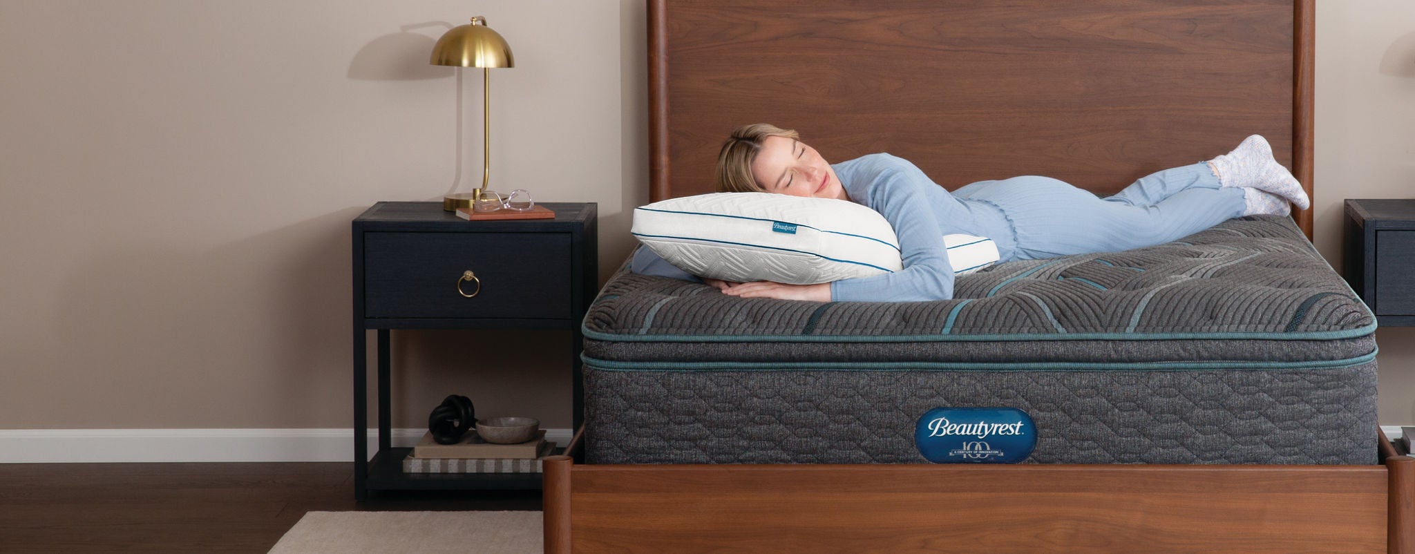 Woman laying on top of Beautyrest mattress with her head on a Beautyrest Absolute Relaxation Pillow