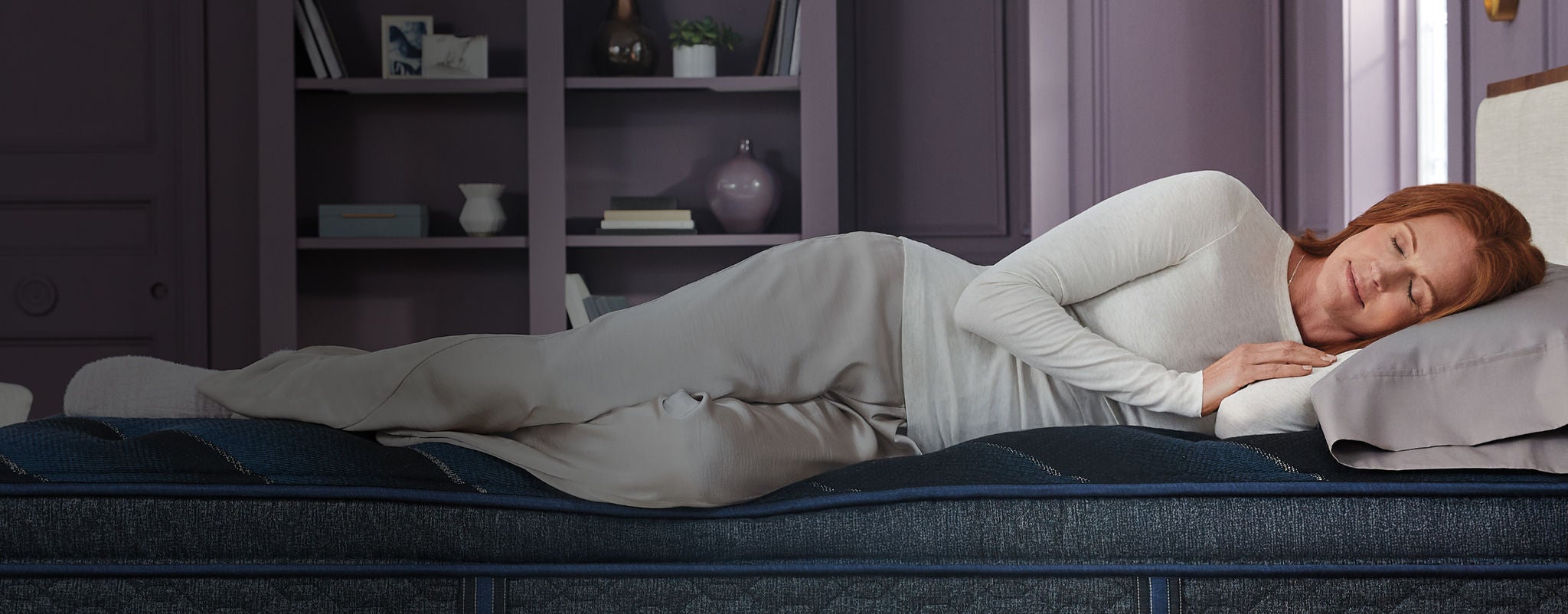 Woman sleeping on a Beautyrest World Class mattress in a bedroom.