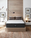 The Beautyrest Hybrid BRX1000-IP Medium mattress in a bedroom on a wooden bed