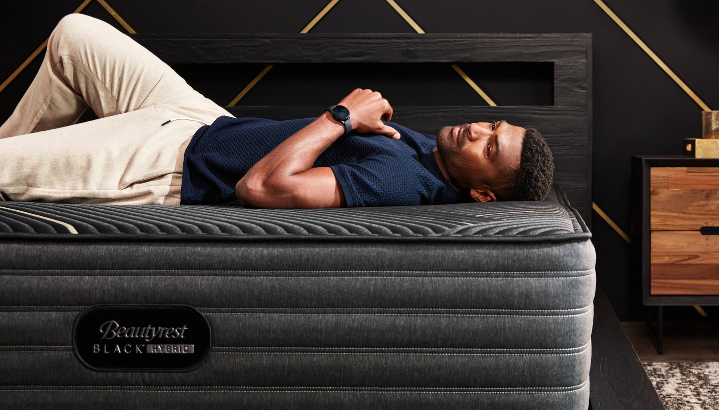Man laying across a Beautyrest mattress in a bedroom