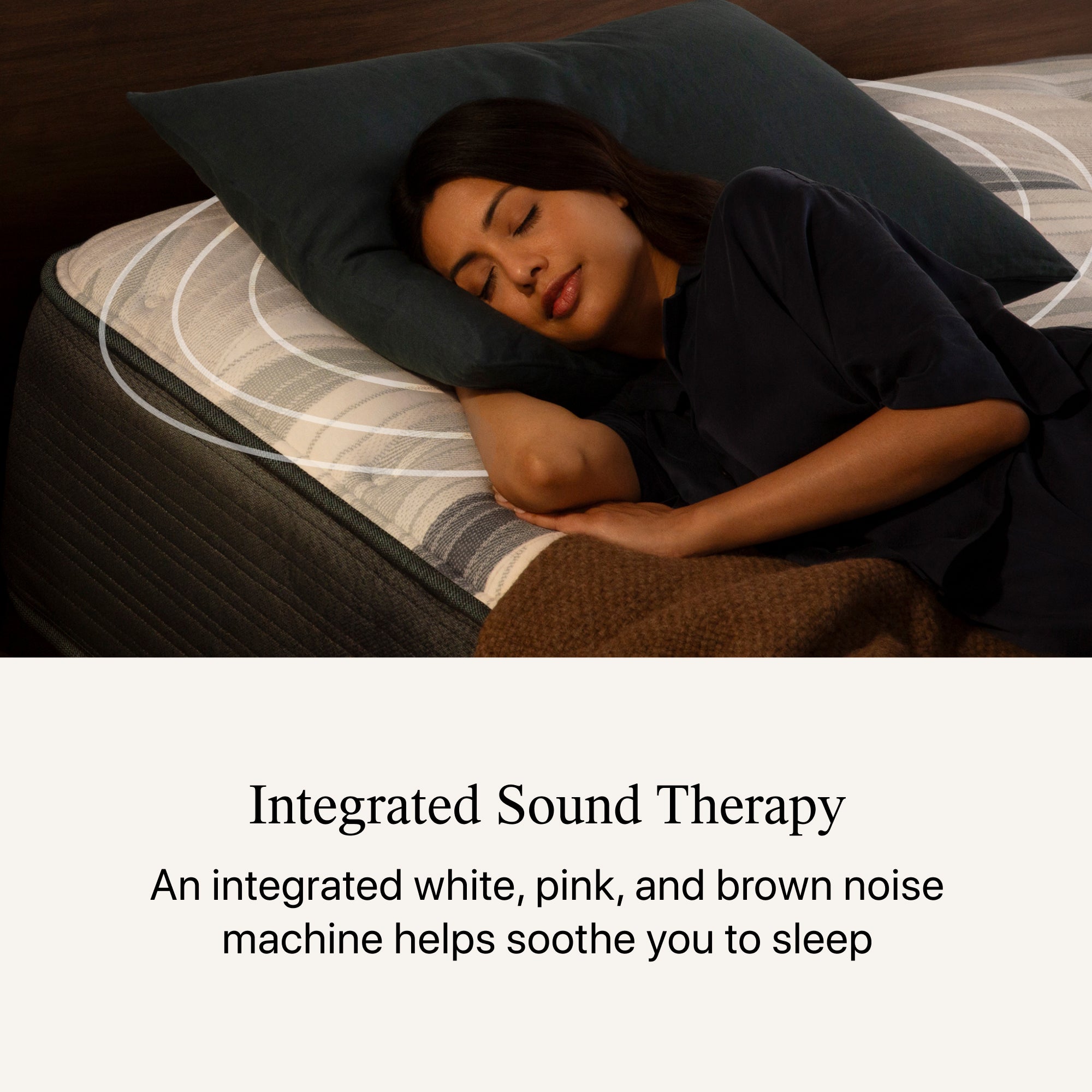 Woman laying on a mattress elevated at the top within a  Motion Restore Base. below the image, the headline states Integrated Sound Therapy  An integrated white, pink, and brown noise machine helps soothe you to sleep