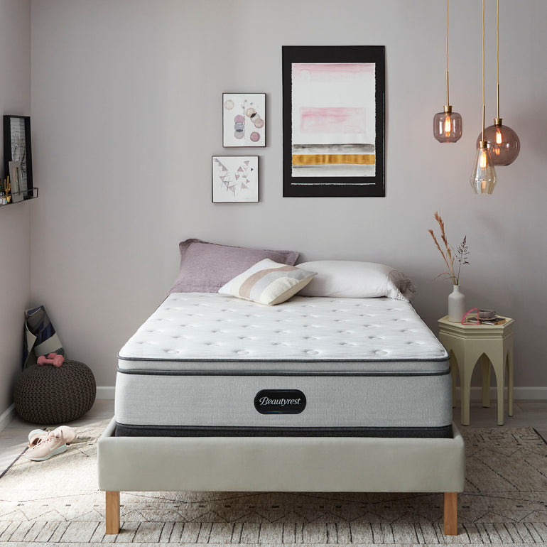 The Beautyrest BR800 Plush Pillow Top mattress in a bedroom on a beige bed