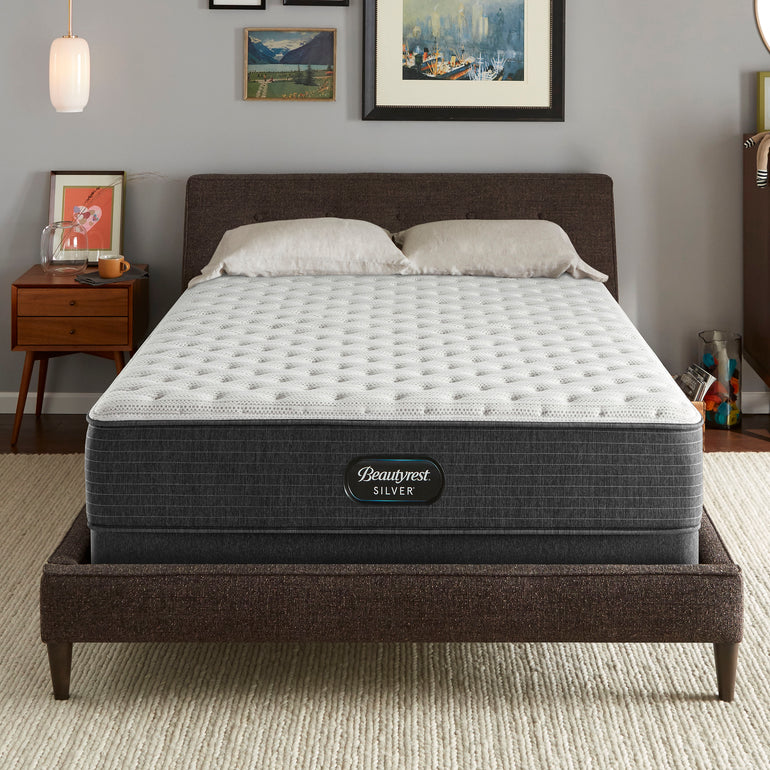 The Beautyrest Silver BRS900 Extra Firm mattress in a bedroom on a brown bed