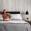 Woman laughing in bed watching TV from the Beautyrest Black hybrid mattress||series: enhanced lx-class