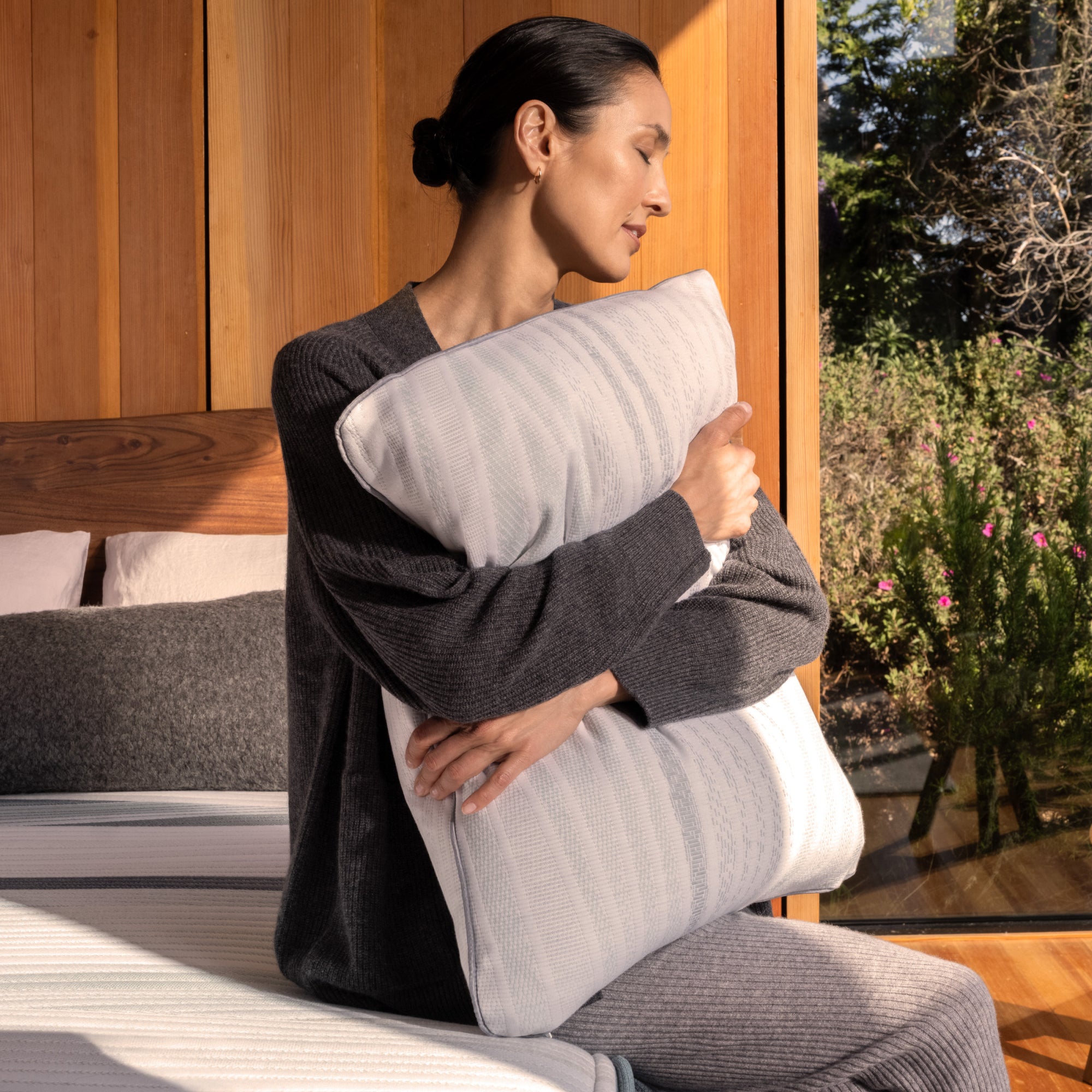 A woman squeezing the Beautyrest Harmony Lux pillow