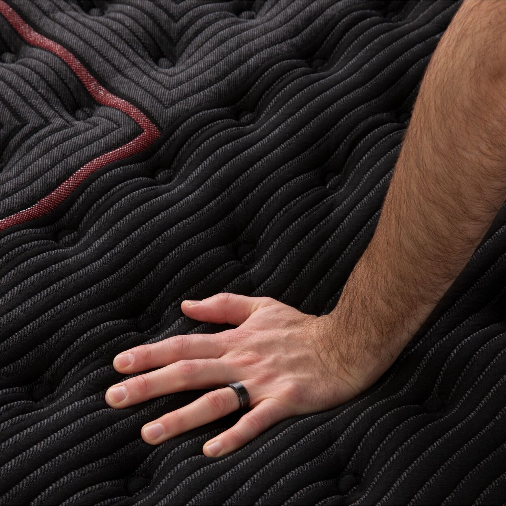 Hand pressing the fabric of the Beautyrest Black mattress|| series: deluxe c-class || feel: extra firm