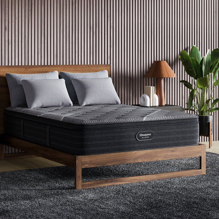 The Beautyrest Black b-class mattress in a bedroom on a wooden bed|| series: grand b-class || feel: plush pillow top