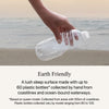 A hand holding a water bottle by the ocean showing the earth friendly value of the Beautyrest Harmony Lux Hybrid  mattress || series: Premier Ocean View Island