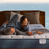 A couple laying across the bed laughing on the Beautyrest Harmony Lux mattress || series: Premier Anchor Island || feel: medium pillow top