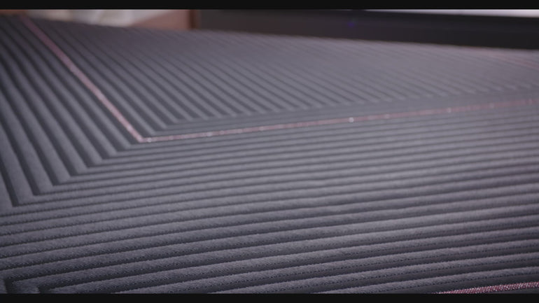 A hand pressing on the material of the Beautyrest Black hybrid mattress||series: deluxe cx-class