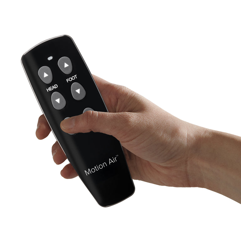 A hand holding the remote control for the Beautyrest Motion Air adjustable base